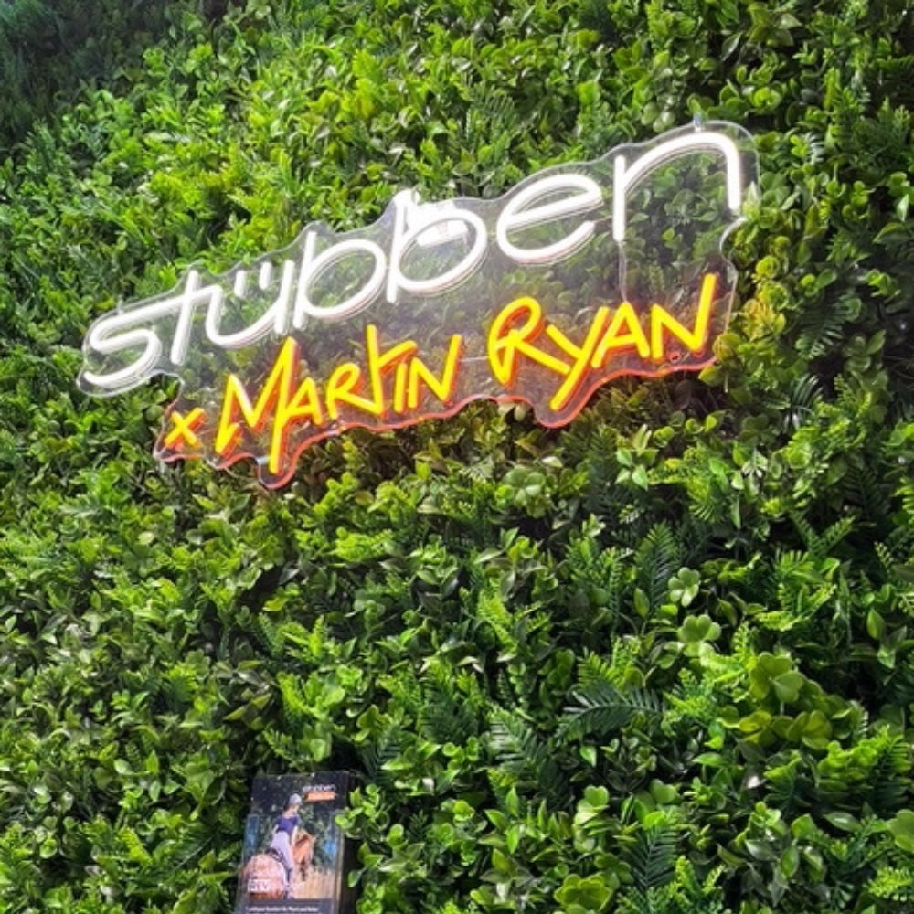 Neonschild montiert auf Blumenwand am Messestand