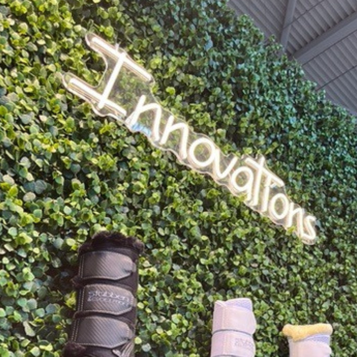 Neonschild von Neon Nova auf einer Blumenwand für eine Veranstaltung