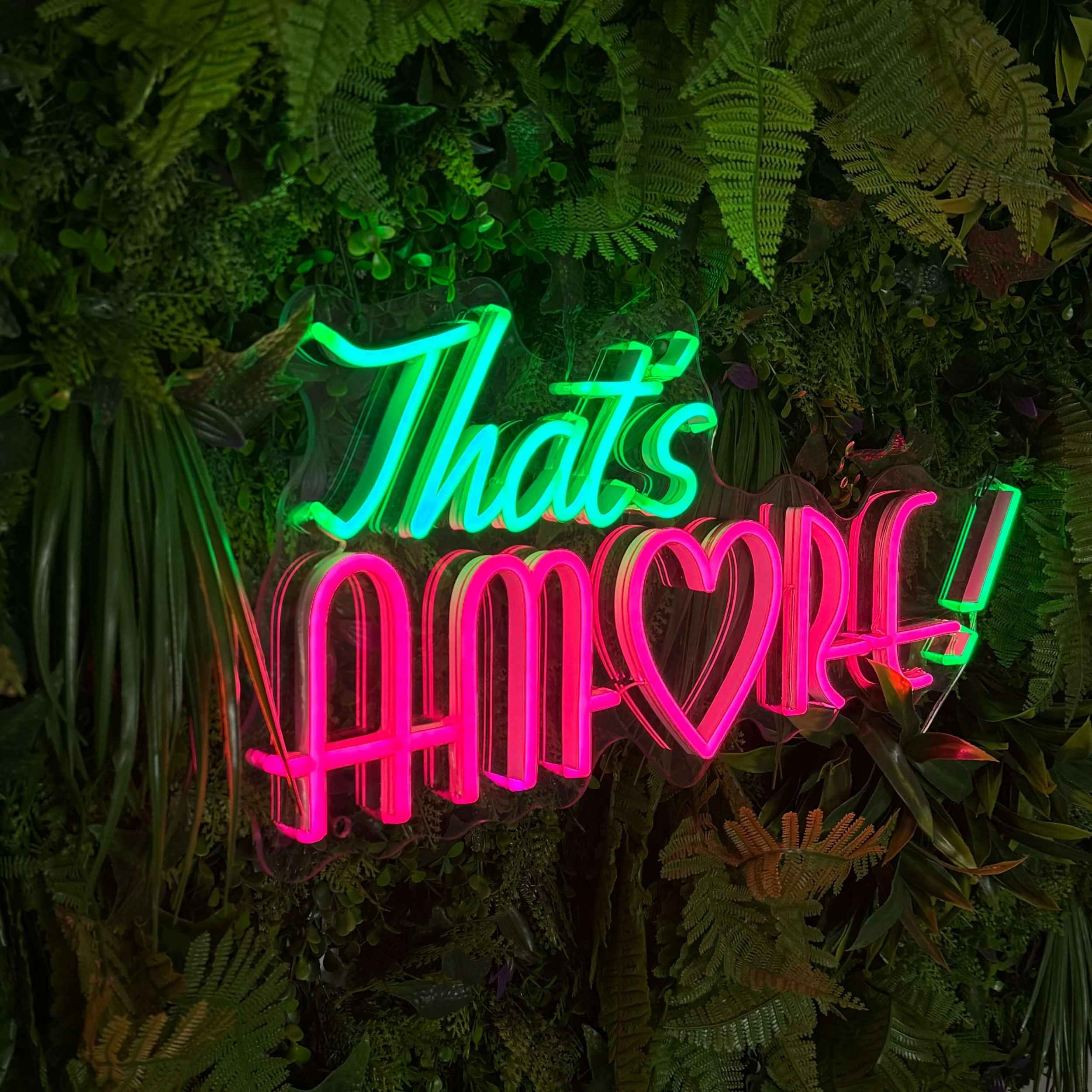 Neon Schild auf Blumenwand Thats Amore